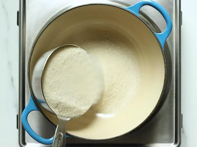 adding sugar to make syrup for jalebi