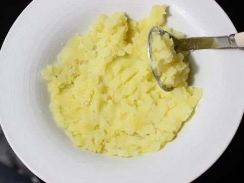 mashing potatoes to stuff bread roll