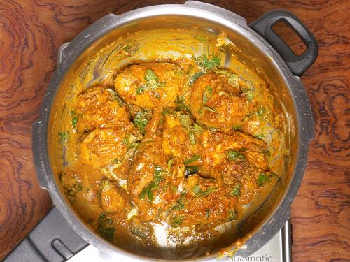 layering the marinade in pot to make chicken biryani