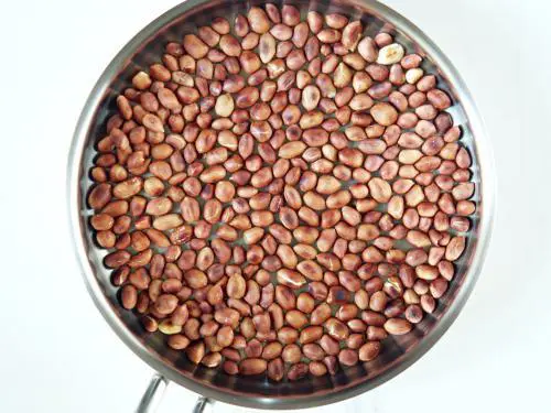 roasting peanuts until golden to make churumuri