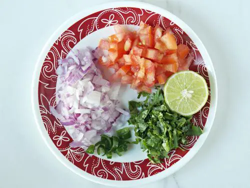 chopping onions tomatoes to make churumuri