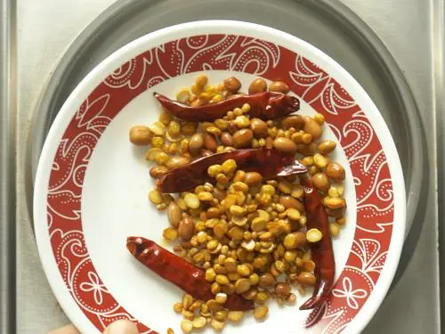 cooling fried ingredients to make allam chutney