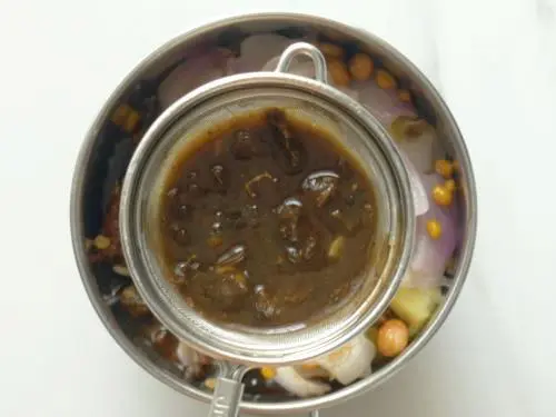 pouring tamarind water to make ginger chutney