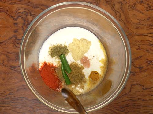adding spices & yogurt to a bowl for hyderabadi biryani