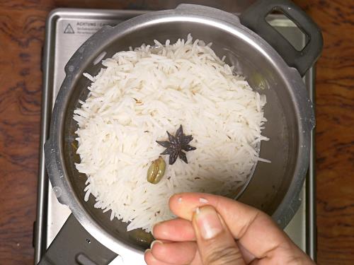 checking rice before draining to make hyderabadi biryani