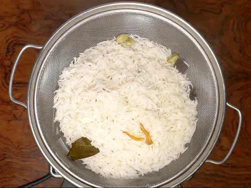draining basmati rice to colander for hyderabadi biryani recipe