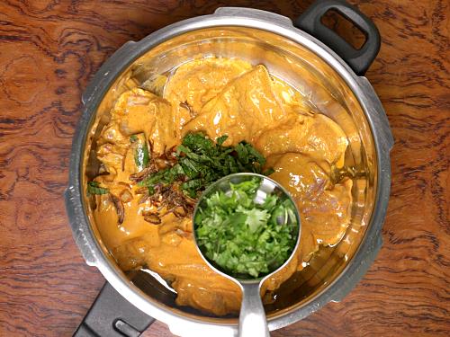 adding herbs fried onions & laering marinade to make hyderabadi biryani