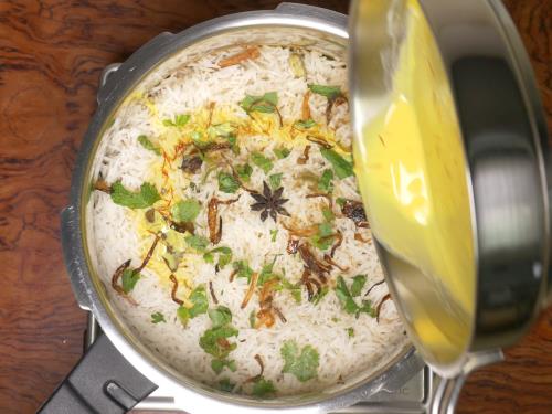 layering onions herbs spices ghee saffron milk for hyderabadi biryani