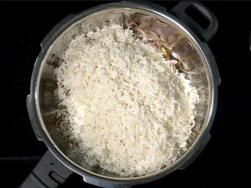 adding basmati rice to make jeera rice
