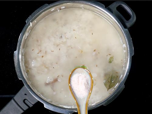 pouring water and adding salt to make jeera rice