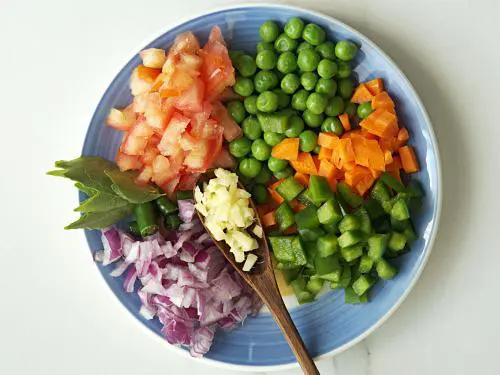 chopping veggies & ginger to make khara bath