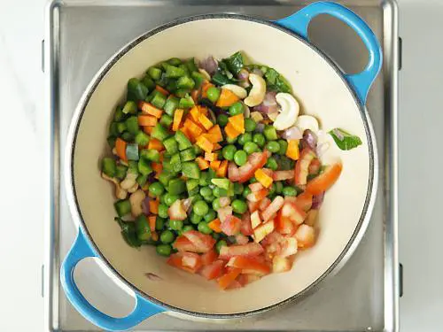 adding all veggies to pan for khara bath recipe