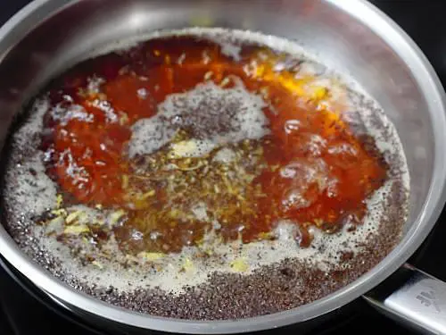simmering tea decoction with spices to make masala chai