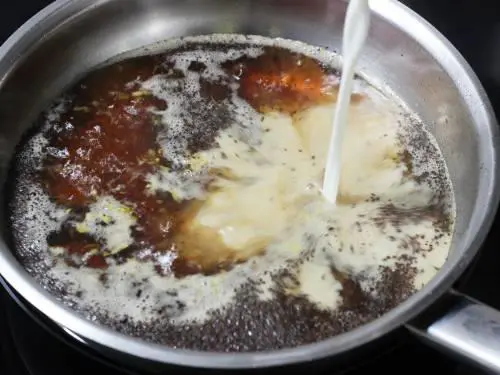 adding milk to pan to make masala chai