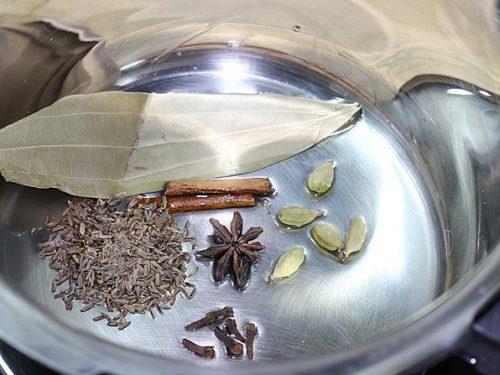 Frying spices in ghee to make mutton biryani