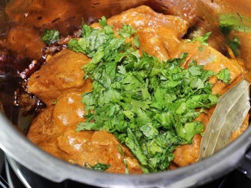 adding marinade coriander leaves to make mutton biryani