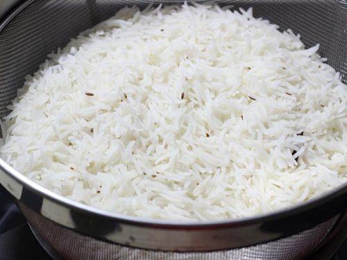 arroz escurrido al colador para hacer biryani de cordero