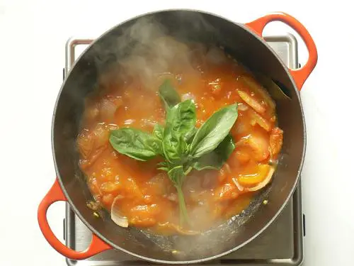 adding basil to pan