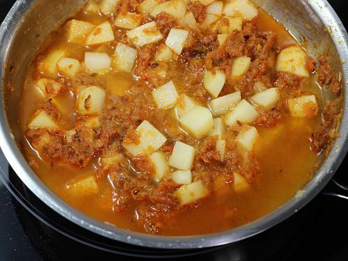 pouring water to make potato curry