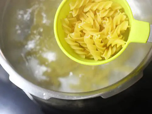 adding pasta to boiling water