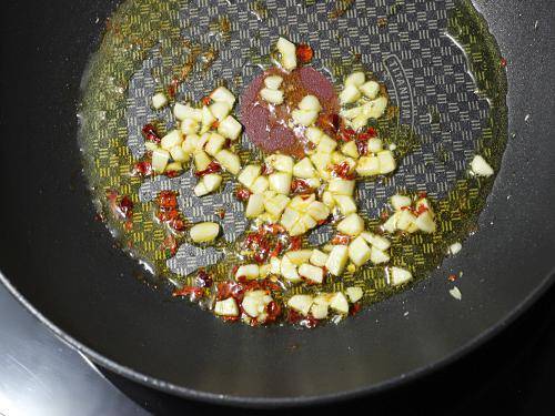 frying garlic chilli flakes to make red sauce pasta