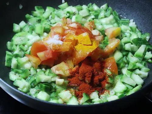 adding spice powders to make beerakaya curry