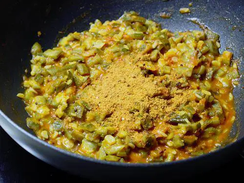 adding spice powder to make ridge gourd curry