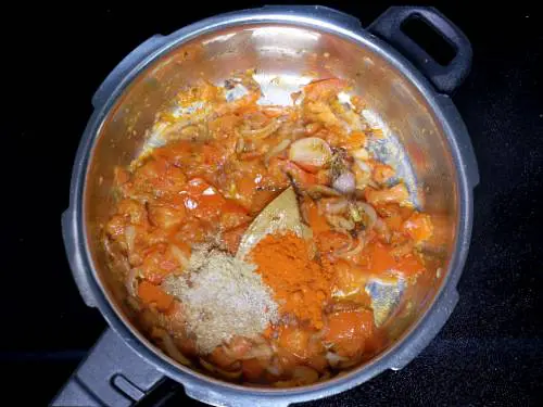 adding spice powders to make tomato rice