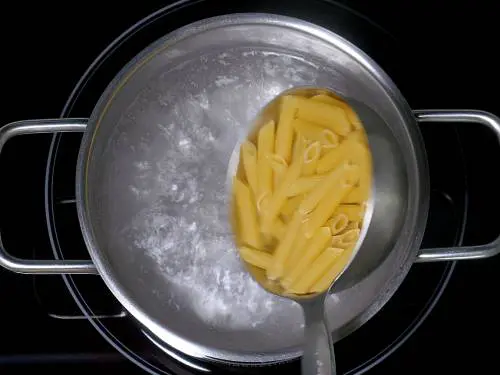 adding pasta to boiling water