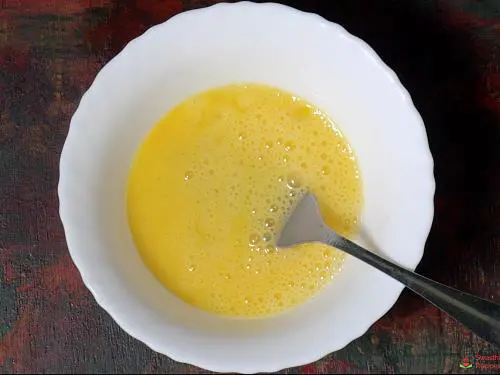 beating eggs in a bowl for bread omelette