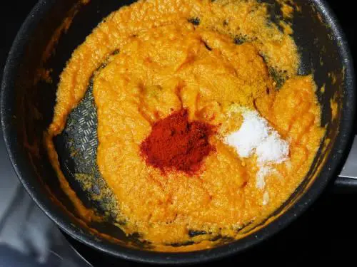 adding chilli powder to make paneer makhani