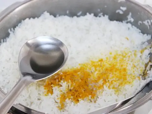 pouring oil over rice to make pulihora