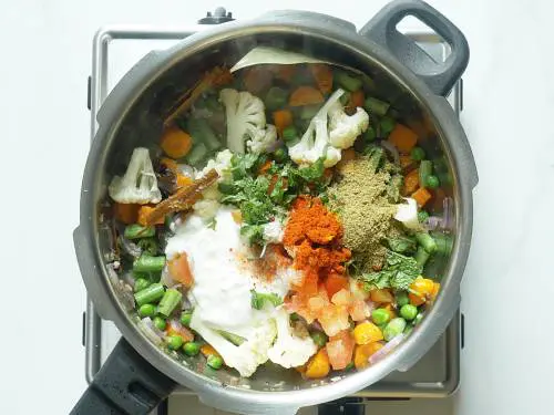 adding spice powders to make veg biryani