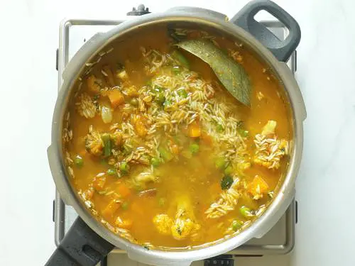 pouring water to make veg biryani