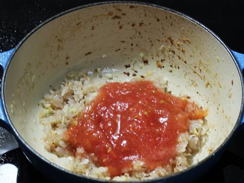 adding tomatoes to the pan