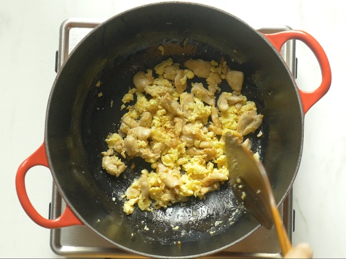 frying eggs to make chicken fried rice