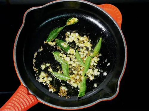 frying curry leaves to make kakarakaya fry