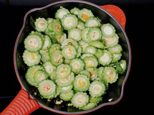 adding sliced bitter gourd to fry