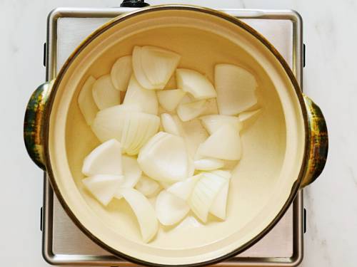 adding onions to pot to make clear soup