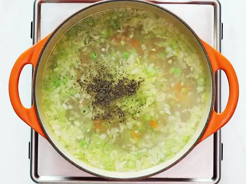 adding pepper in vegetable soup