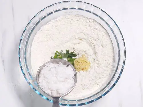 adding coconut to make goli baje batter