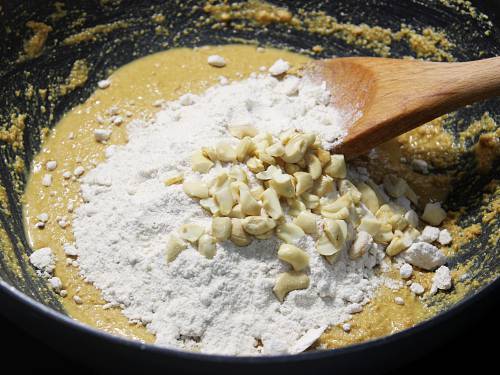 adding sugar to roasted flour to make besan ladoo