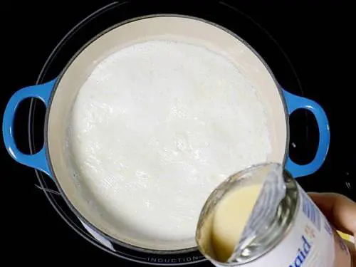 pouring condensed milk to make basundi