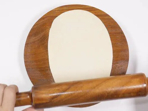 rolling dough to oval shaped bhatura 