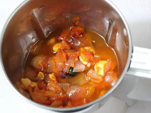 Pouring water to blend the gravy for paneer tikka masala