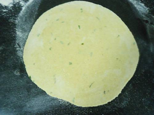 rolling dough to make a paneer paratha