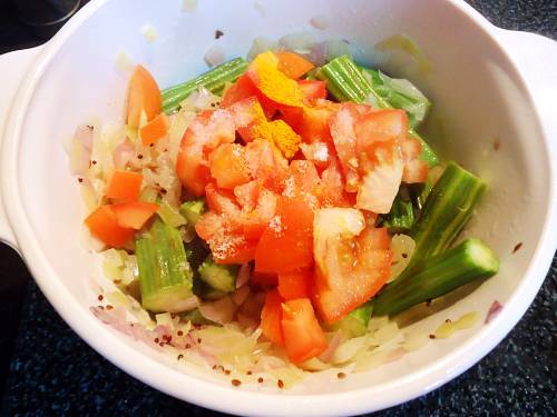 adding tomatoes to make drumstick curry