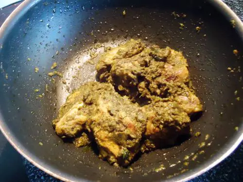 green chicken in pan with masala