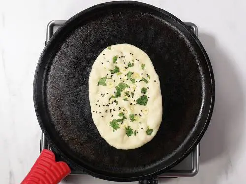 toasting garlic butter naan on cast iron skillet