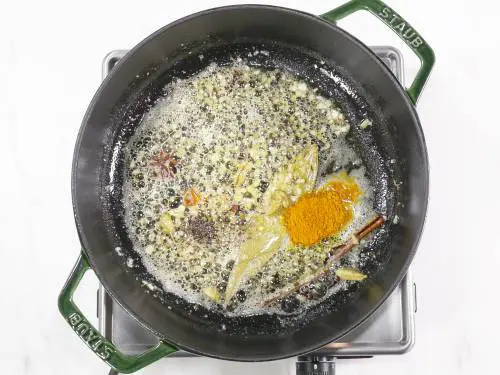 adding turmeric and pepper to make turmeric rice